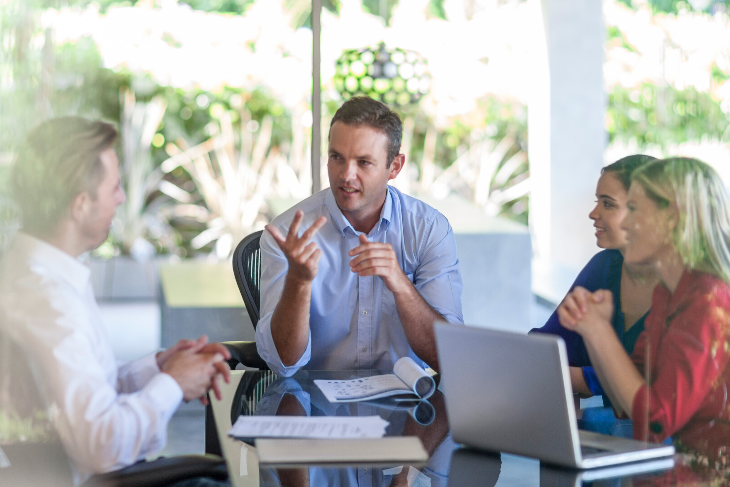 Spotkanie zespołu Umbrella ITFS na tarasie biurowym – dynamiczna dyskusja przy laptopie i dokumentach, symbol otwartej komunikacji w BPO